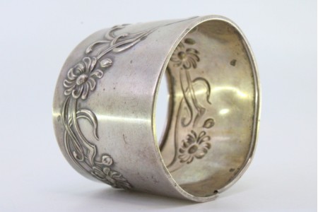  Argola de guardanapo em prata com motivos florais relevados envolvendo cartela para monograma.